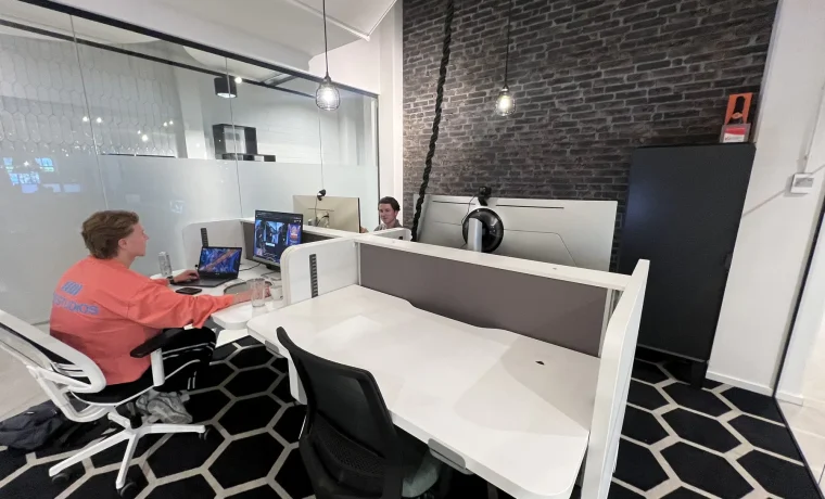 De werkplek bij SiteJob met bureaus, schermen en collega’s.